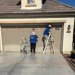 Professional house painting services in Arizona with experienced painters preparing and coating a residential garage exterior