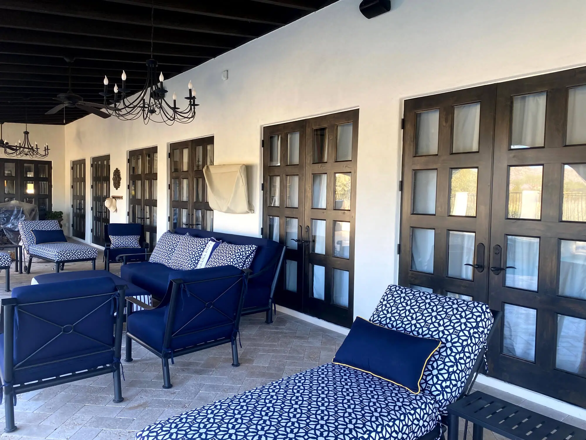 Luxurious covered patio featuring dark wood French doors and white stucco walls expertly finished by Butchers Custom Painting.