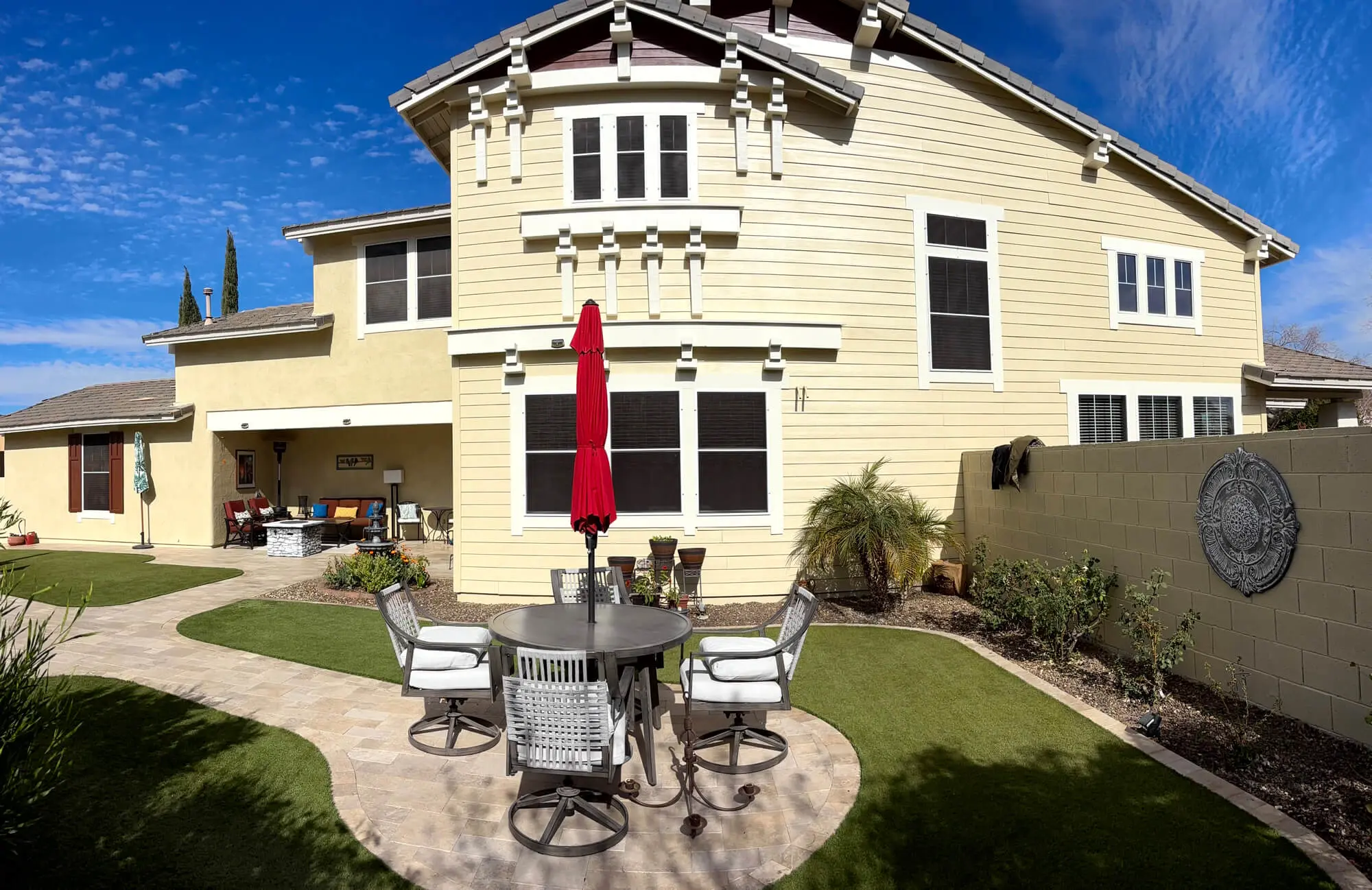 A professionally finished exterior home exterior painted by Butchers Custom Painting featuring cream horizontal siding and crisp white trim.