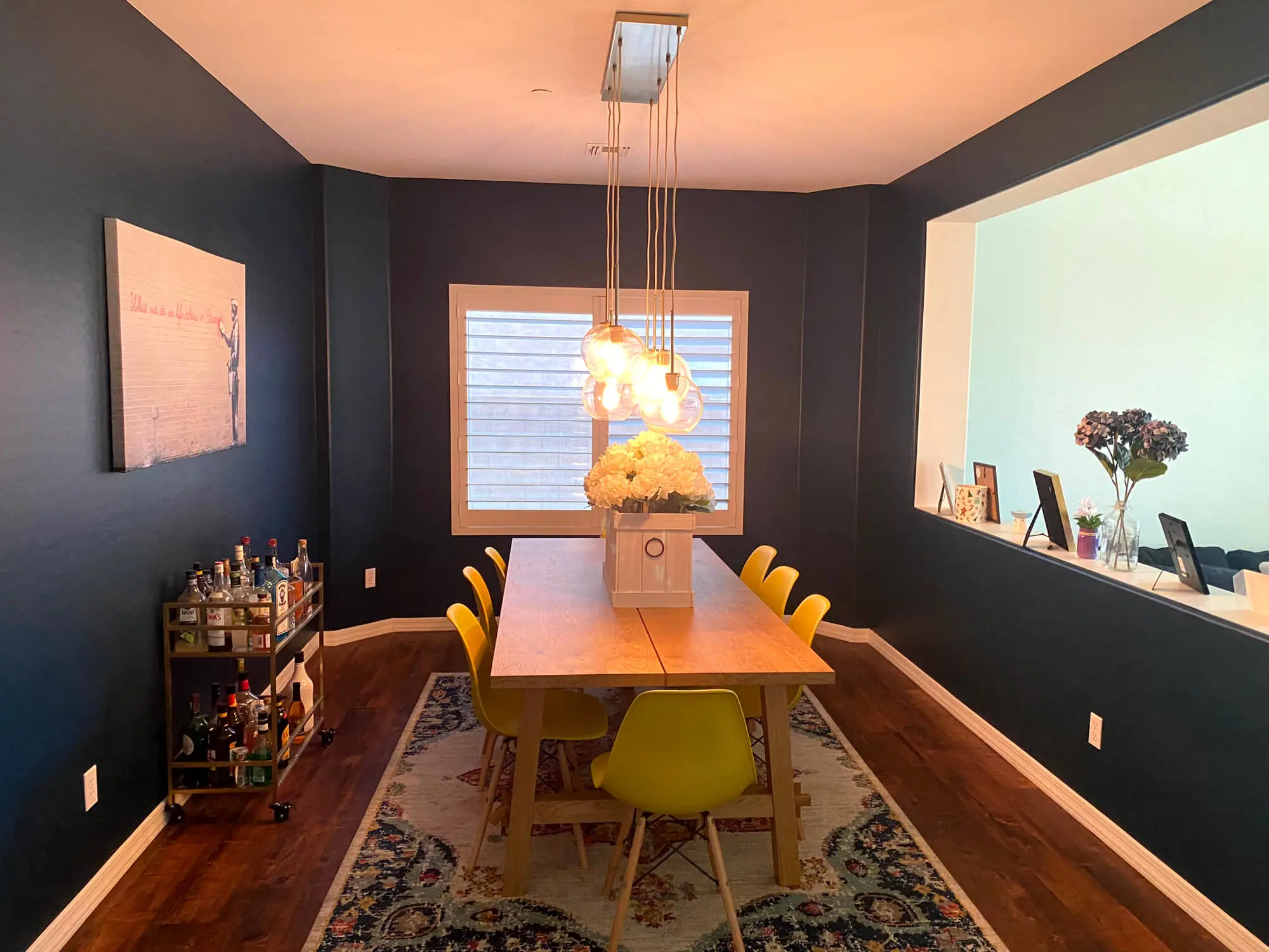 Modern dining room featuring vibrant navy blue walls and crisp white trim expertly finished by Butchers Custom Painting.