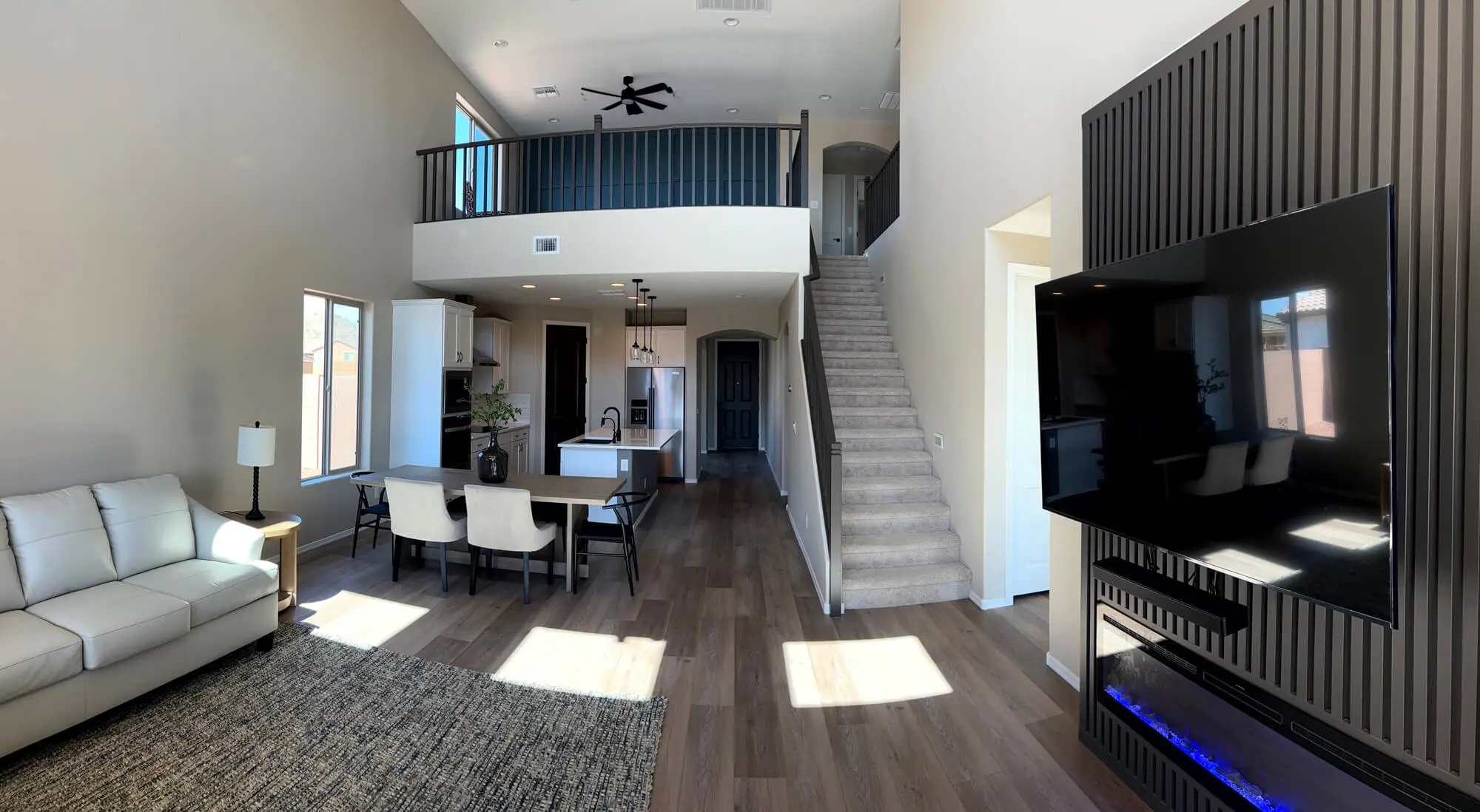 Modern open-concept living area with neutral walls and a black wood-slat accent wall professionally finished by Butchers Custom Painting.