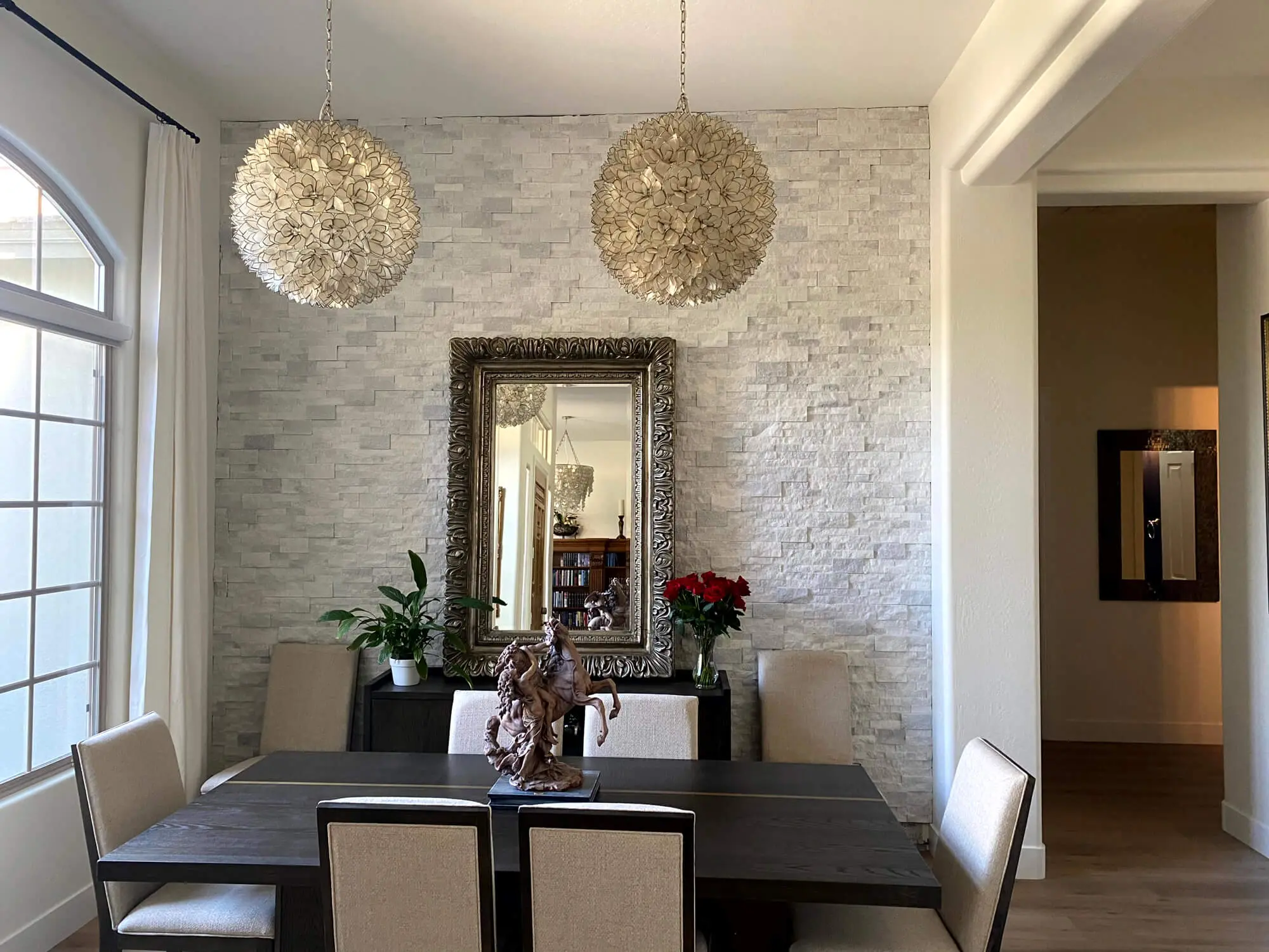 Sophisticated dining room featuring a white stone accent wall and designer lighting, expertly finished by Butchers Custom Painting.