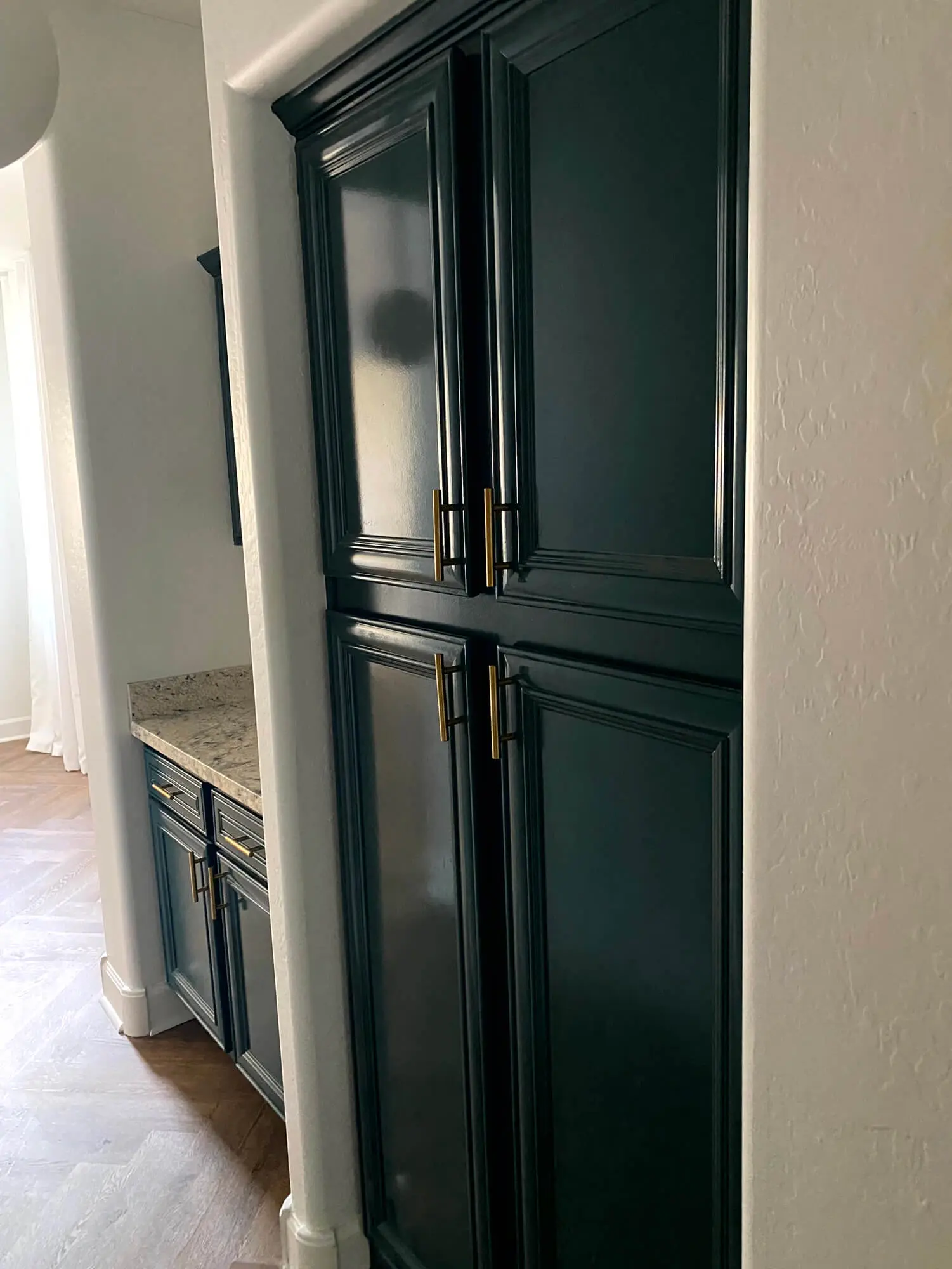 Elegant dark teal kitchen cabinets with gold hardware professionally refinished by Butchers Custom Painting.