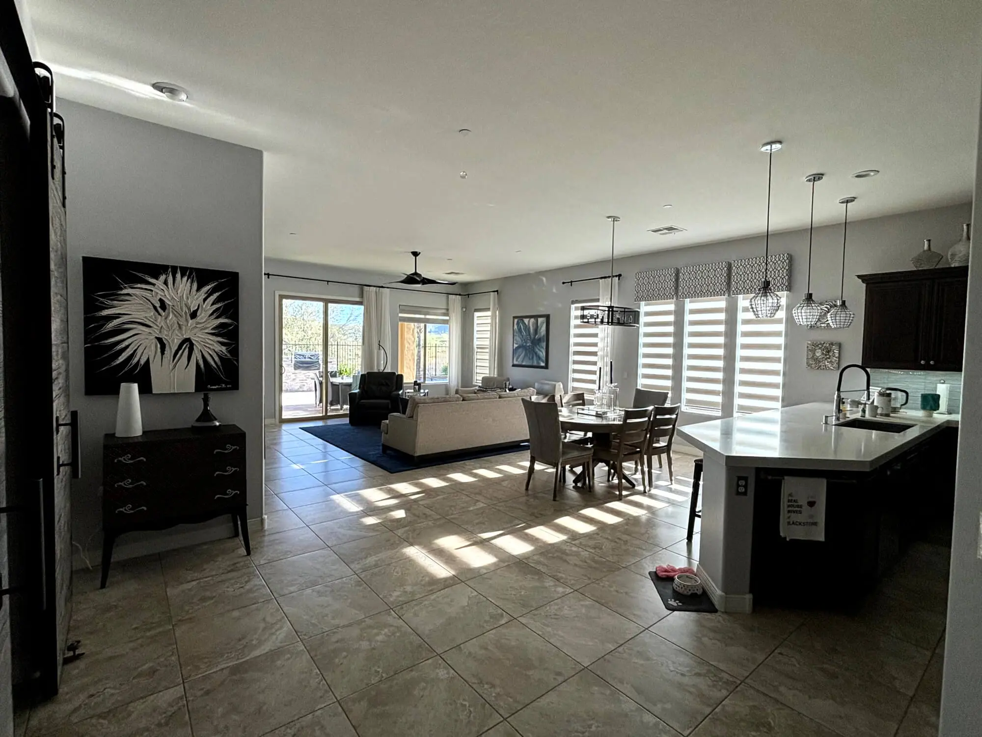 A bright dining room with a hanging chandelier and professional neutral wall finishes completed by Butchers Custom Painting.