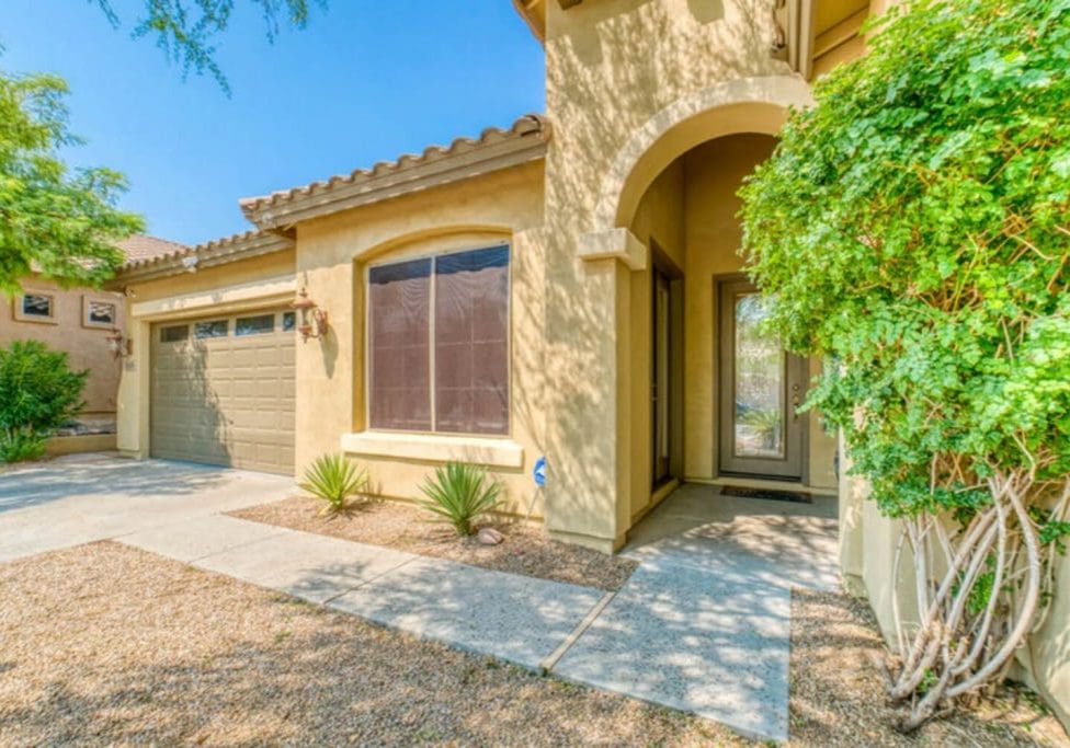 A stucco home with a tile roof and desert landscaping in a Peoria, Arizona HOA community.