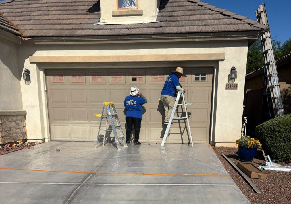 Professional house painting services in Arizona with experienced painters preparing and coating a residential garage exterior