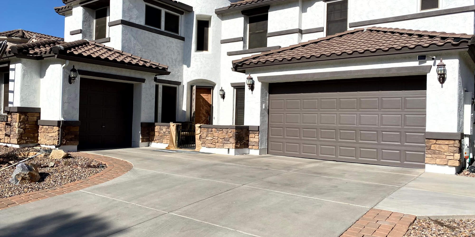 Modern Mediterranean villa featuring crisp white stucco and dark trim by Butchers Custom Painting