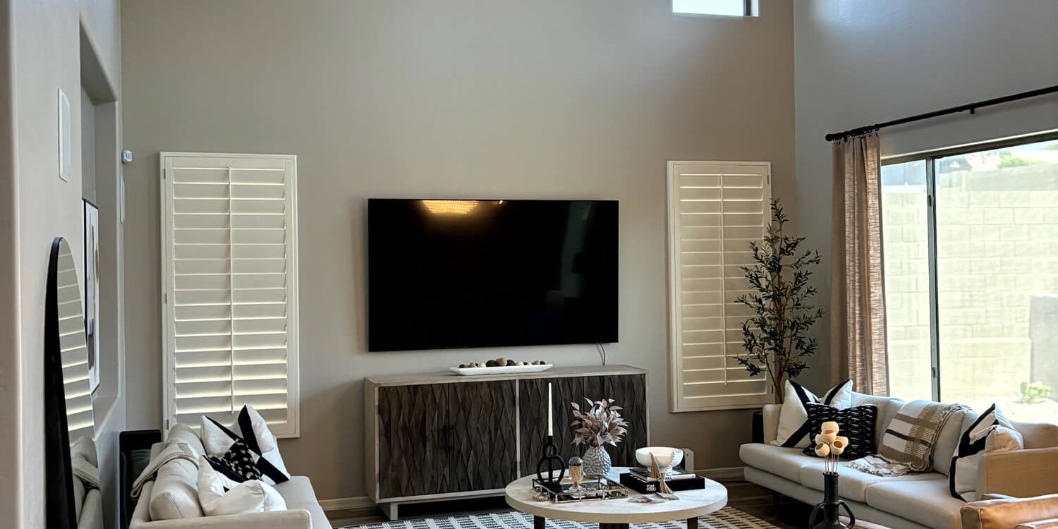 Modern high-ceiling living room with neutral walls and professional interior paint finishes by Butchers Custom Painting.