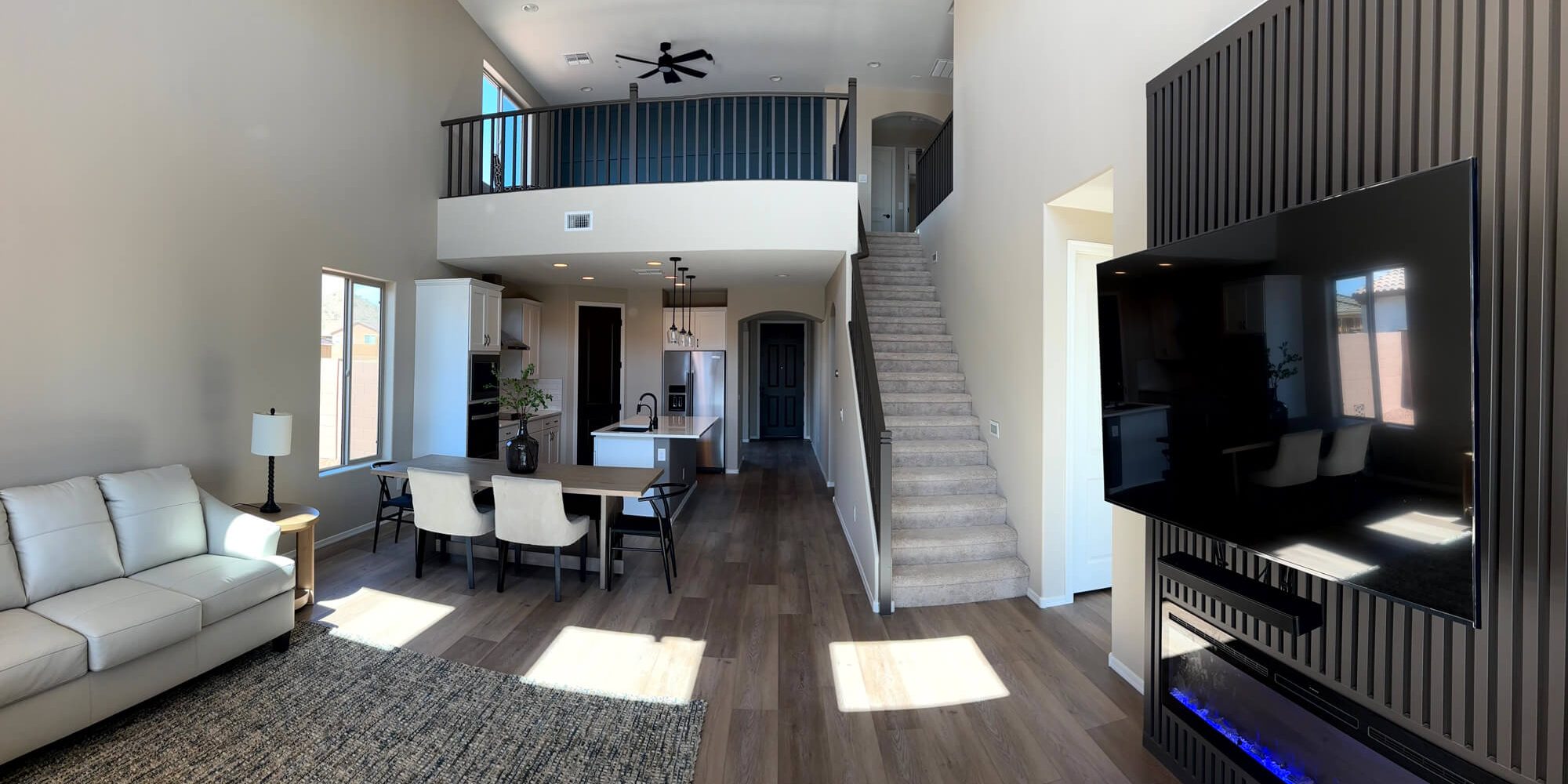 Modern open-concept living area with neutral walls and a black wood-slat accent wall professionally finished by Butchers Custom Painting.